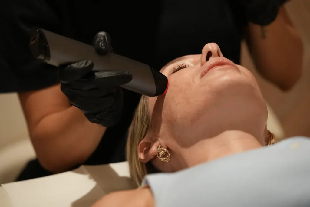 Practitioner performing a regenerative aesthetics skin treatment along a client's jawline at Blast Institute